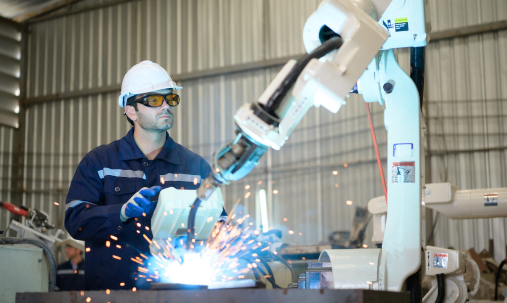 personnel manipulating parameters of robotic welding using control panel